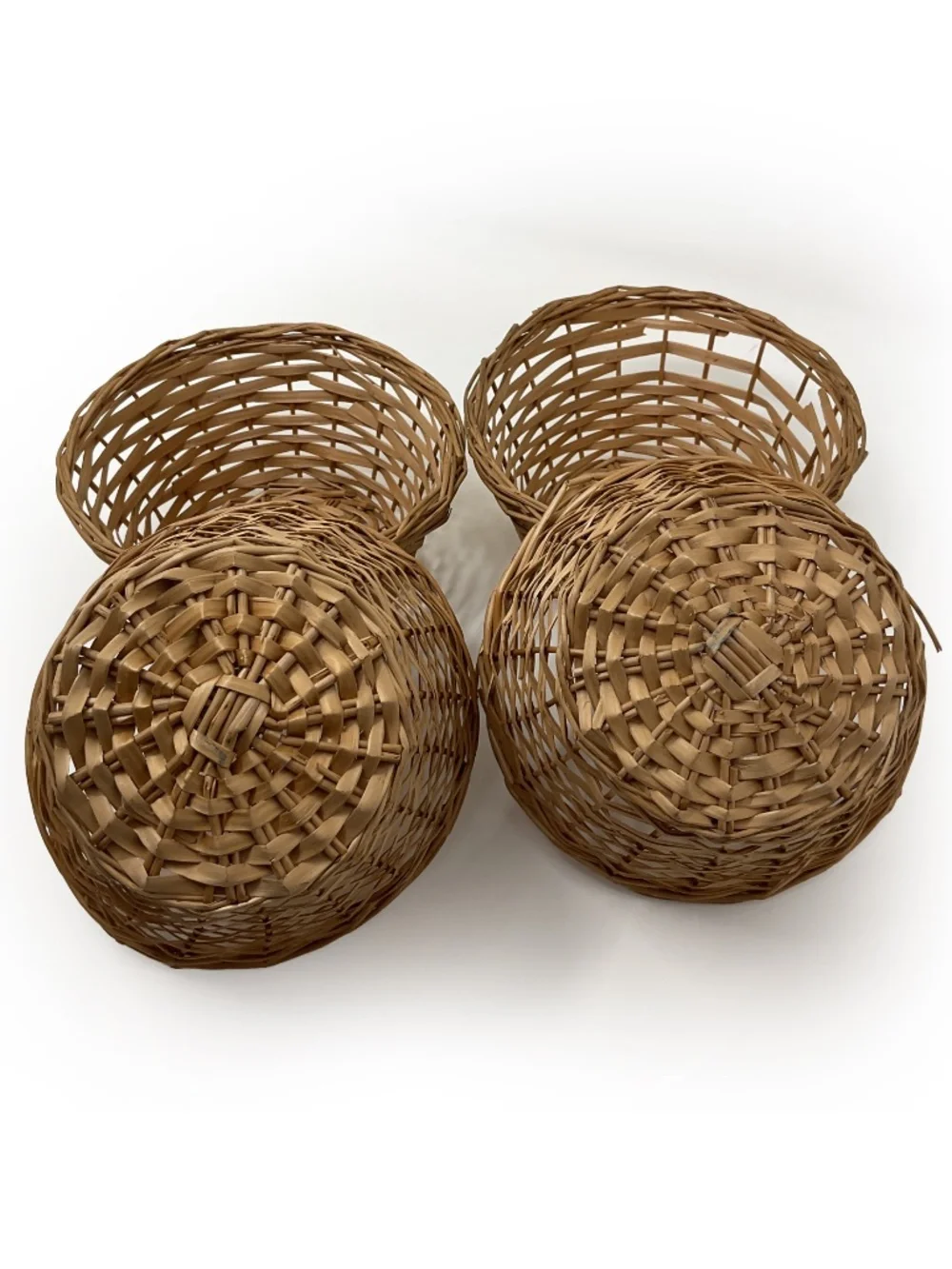 four small vintage round wicker woven wicker baskets with an open-lattice design